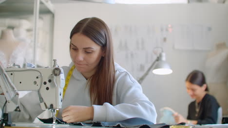 mujer costurera trabajando en una máquina de coser en la tienda para coser ropa. trabajando juntos en un taller de coser