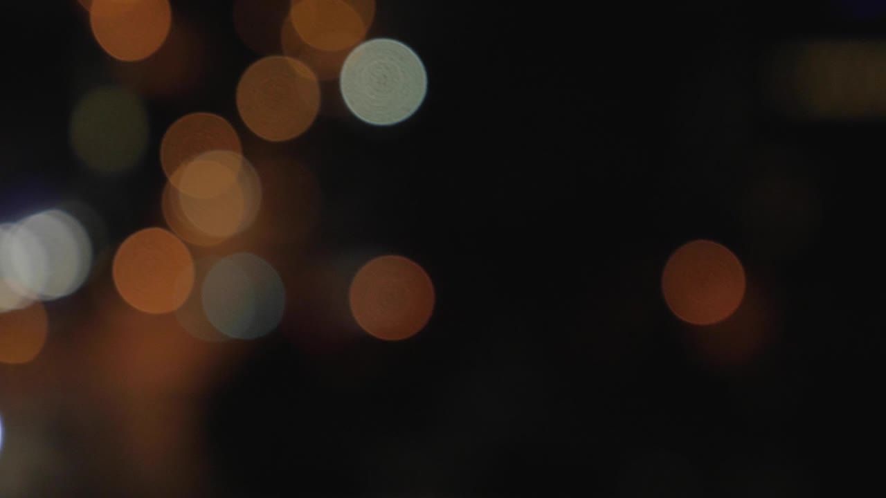 Defocused Night City Lights near Miami Beach. Color Blurred bokeh of people and cars. Pan to left 4K.