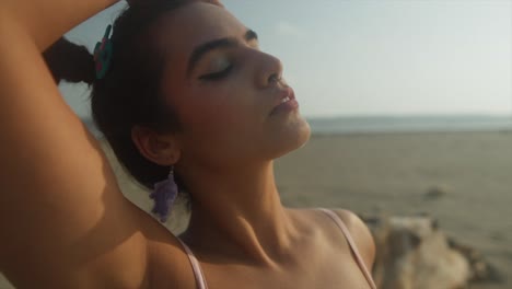 Cinematic-close-up-shot-in-slow-motion-of-an-Indian-fashion-model-posing-on-a-sandy-beach-in-Goa-India,-Slomo