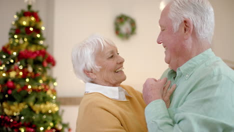 Feliz-Pareja-Caucásica-Mayor-Bailando-Junto-Al-árbol-De-Navidad-En-Casa,-Cámara-Lenta