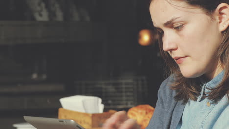 woman using tablet computer touchscreen in cafe