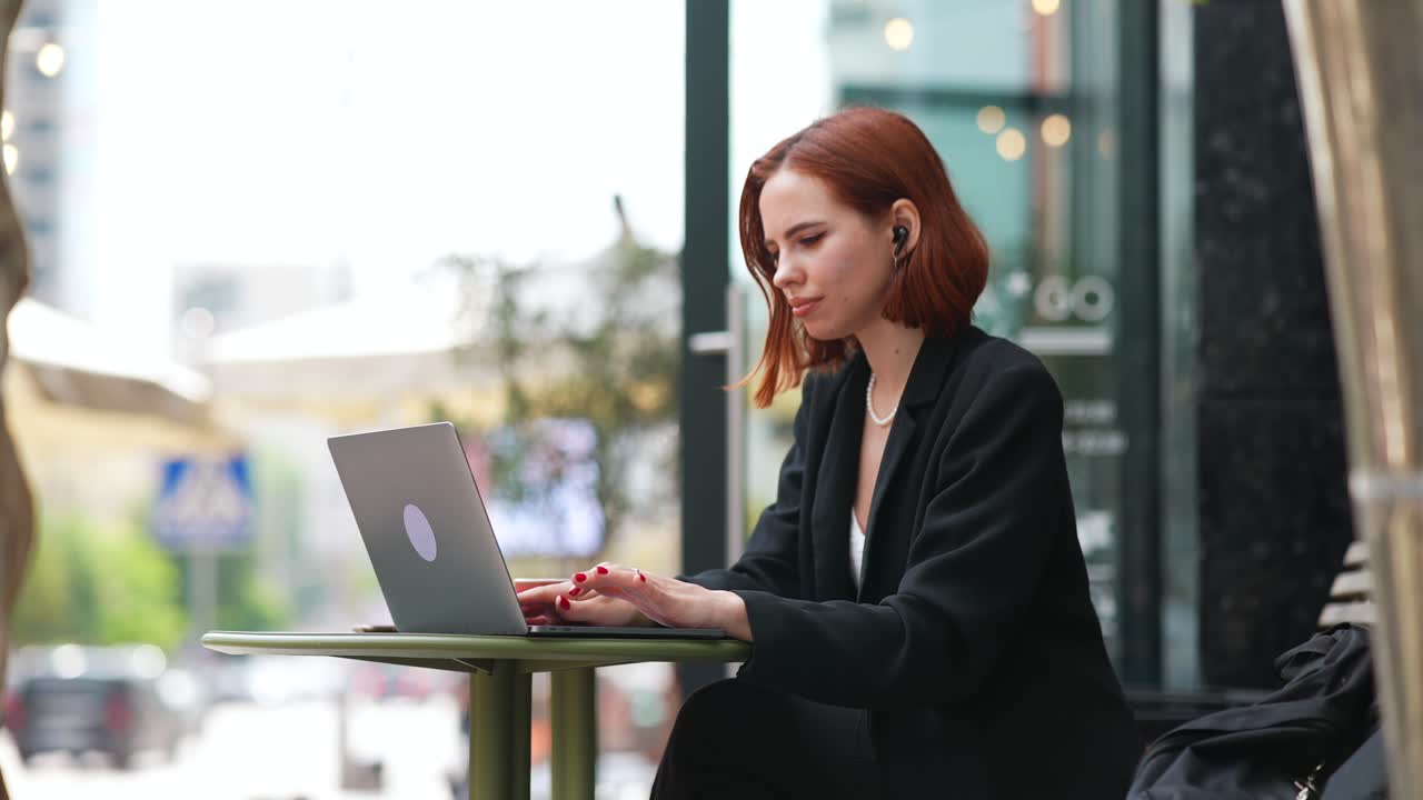 Donna che lavora al computer portatile in un caffè