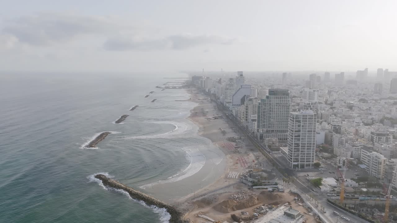 Statisk luftfoto i vidvinkel af bugterne og strandene ved hoteller i Tel Aviv, Israel, i morgensolens disede lys