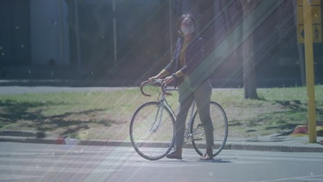 animación de formas que se mueven sobre una mujer biracial con máscara facial caminando con bicicleta