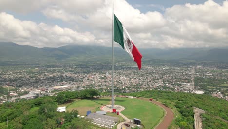 Langsame-Luftaufnahme-Der-Wehenden-Mexikanischen-Unabhängigkeitserklärungsflagge-über-Iguala