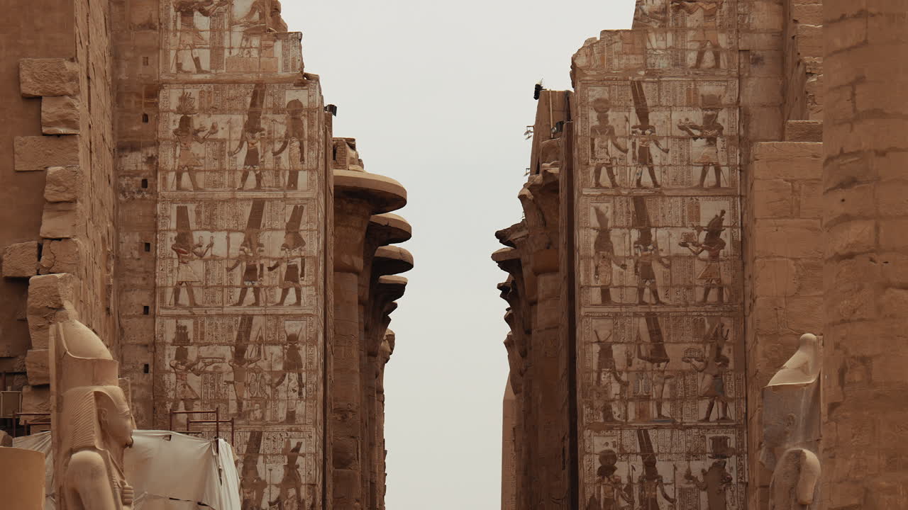 Stone columns and walls with hieroglyphs inside Karnak Temple in Luxor, Egypt. Ancient ruins and historic architecture from the temple site