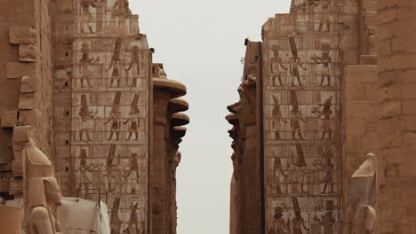 stone columns and walls with hieroglyphs inside karnak temple in luxor, egypt. ancient ruins and historic architecture from the temple site