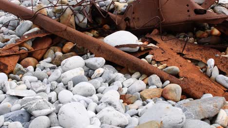 tiro inclinado hacia arriba de piedras y metal viejo oxidado que yacen al aire libre en la naturaleza