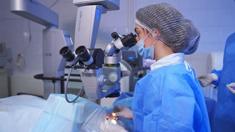 delicate high-precise surgery of an eye. female ophthalmology surgeon holding little tools in both hands to operate eye.