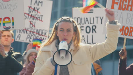 group of protestor with megaphone waving flags on demonstration march for gender equality