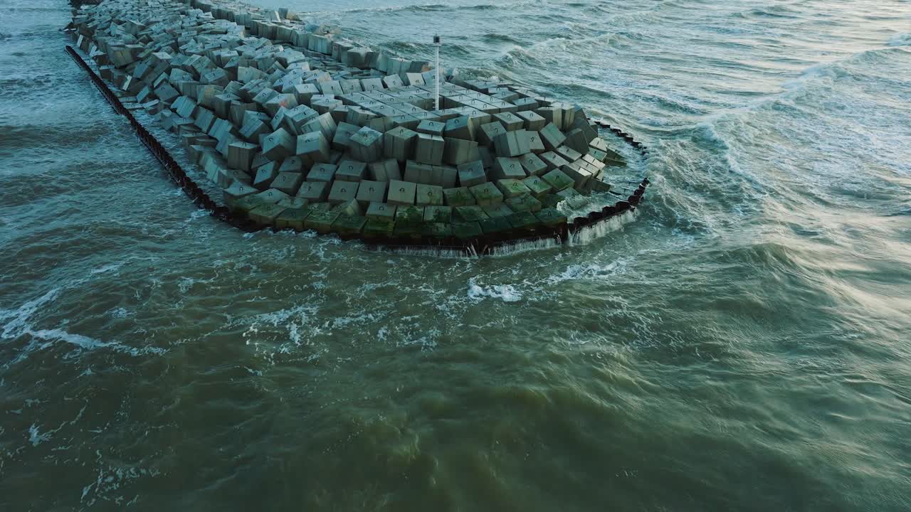 vista aérea del muelle protector de piedra con bloques de hormigón y rocas en la costa del mar báltico en liepaja, letonia, fortaleciendo la playa contra la erosión costera, disparo de drones retrocediendo