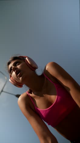 mujer haciendo ejercicio al aire libre con auriculares