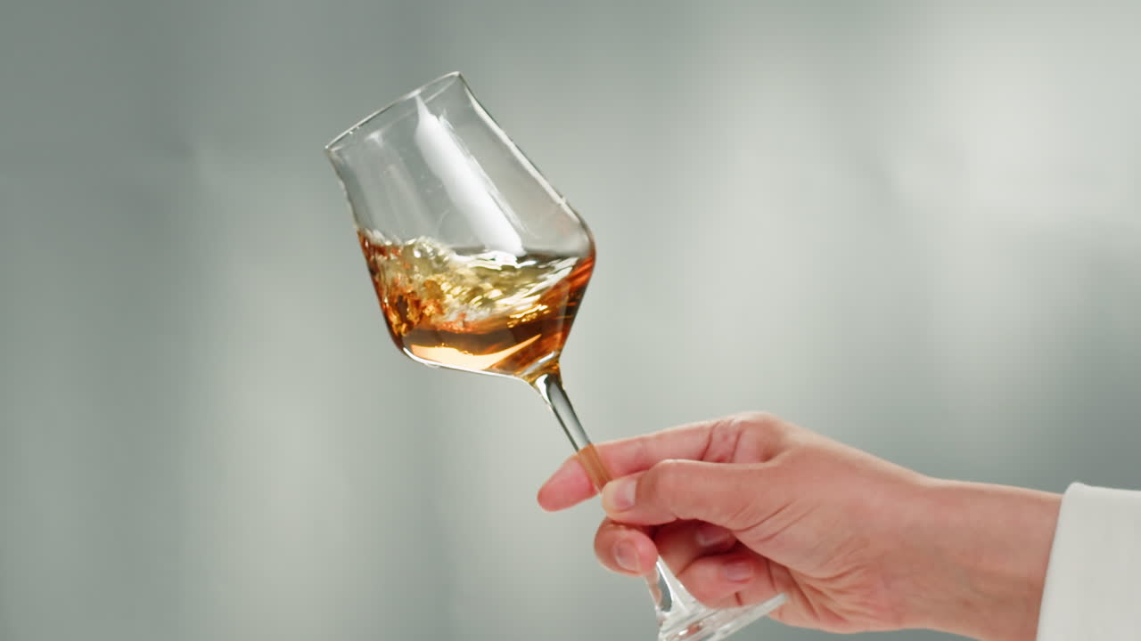 Rose Orange or white wine bottle and glass against a sunset in a peaceful vineyard, pouring of ecological natural wine. Cheers, hands with wine glasses, drinking alcohol.