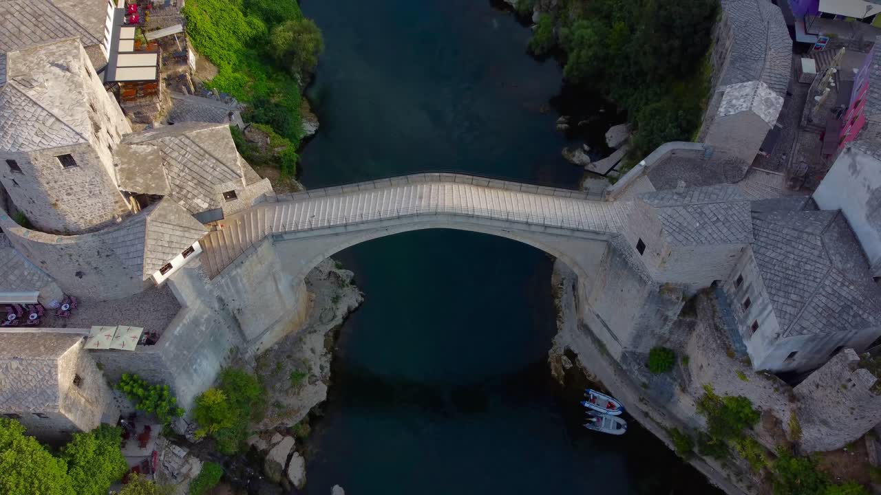 Aerial drone video of iconic Mostar Bridge with no people in on very quiet summer's morning - Mostar, Bosnia and Herzegovina