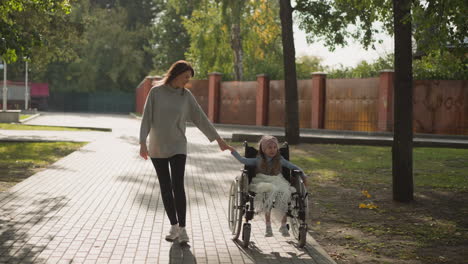 woman walks on stone road holding hand of little daughter