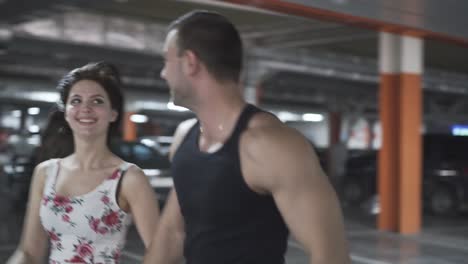 couple in summer dressing runs in underground parking lot