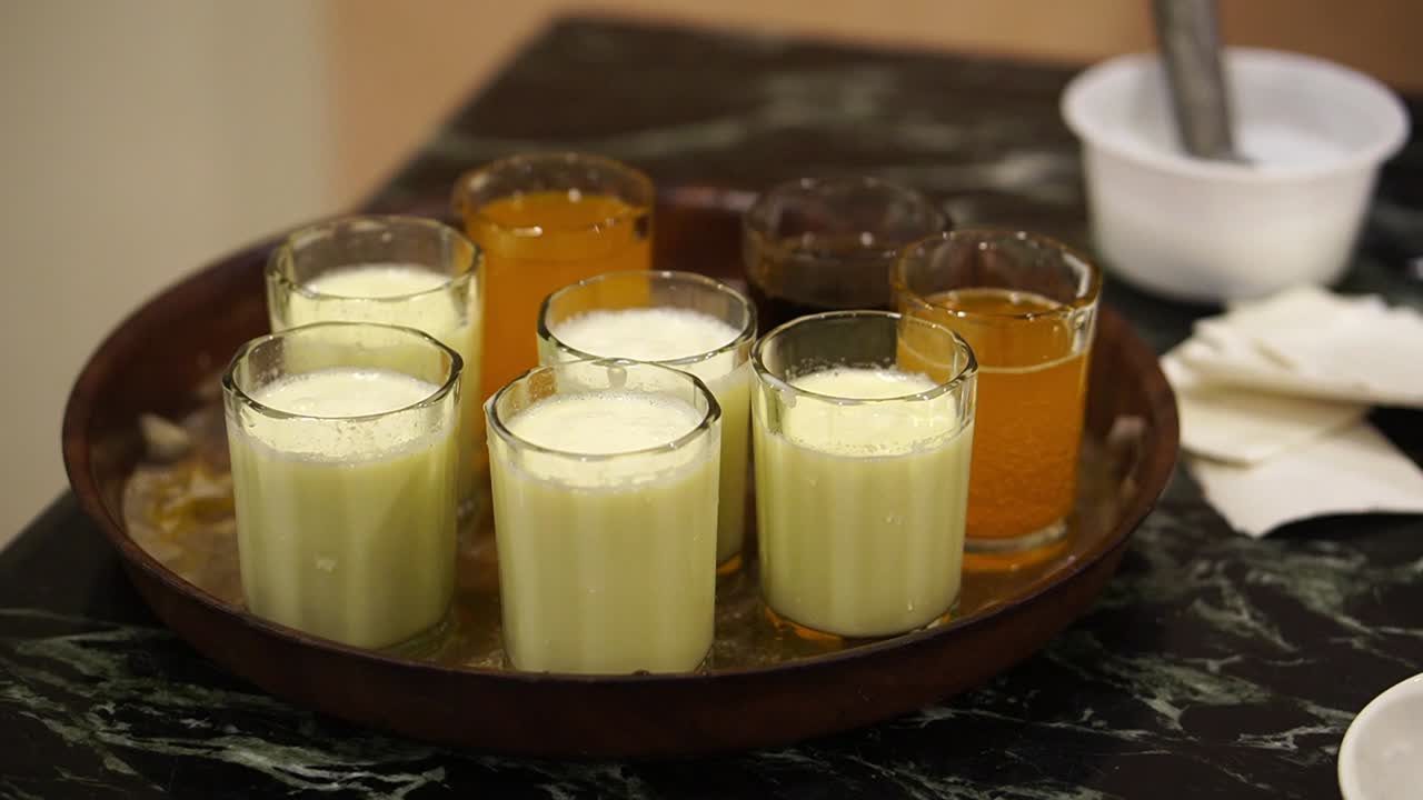 Close up shot of multiple glasses of pineapple and mango juice served with carbonated cola drink