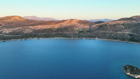 aerial footage of a beach and calm waters during sunset