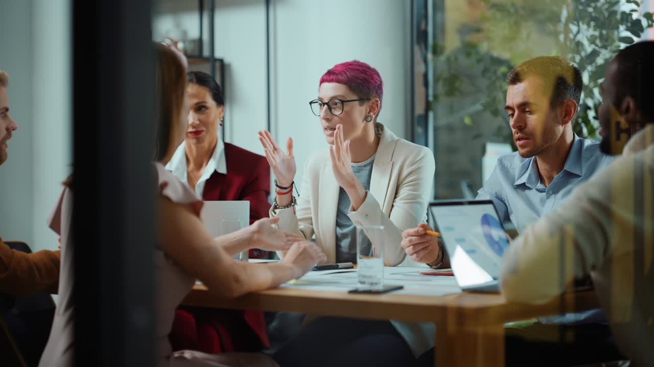 Office Meeting in Conference Room: Beautiful Specialist with Short Pink Hair Talks about Firm Strategy with Diverse Team of Professional Businesspeople. Creative Start-up Team Discusses Big Project