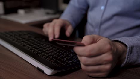 close up of a businessman hands. he enters text on the keyboard and then uses his credit card to pay online. slider footage video.