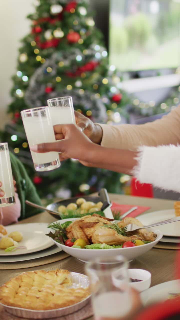 video vertical de una feliz familia afroamericana teniendo una cena de navidad