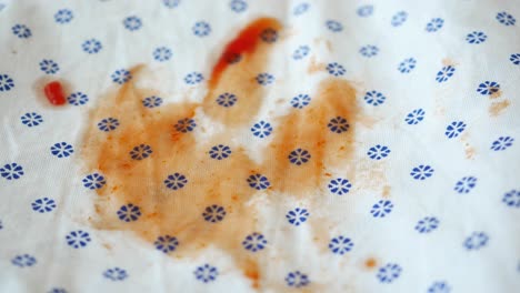 close up of a ketchup stain on a white cloth napkin