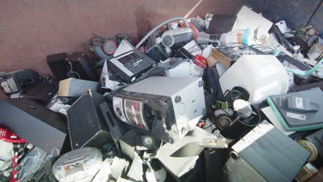 Heap of various kinds of discarded electronics at disposal center, slider shot