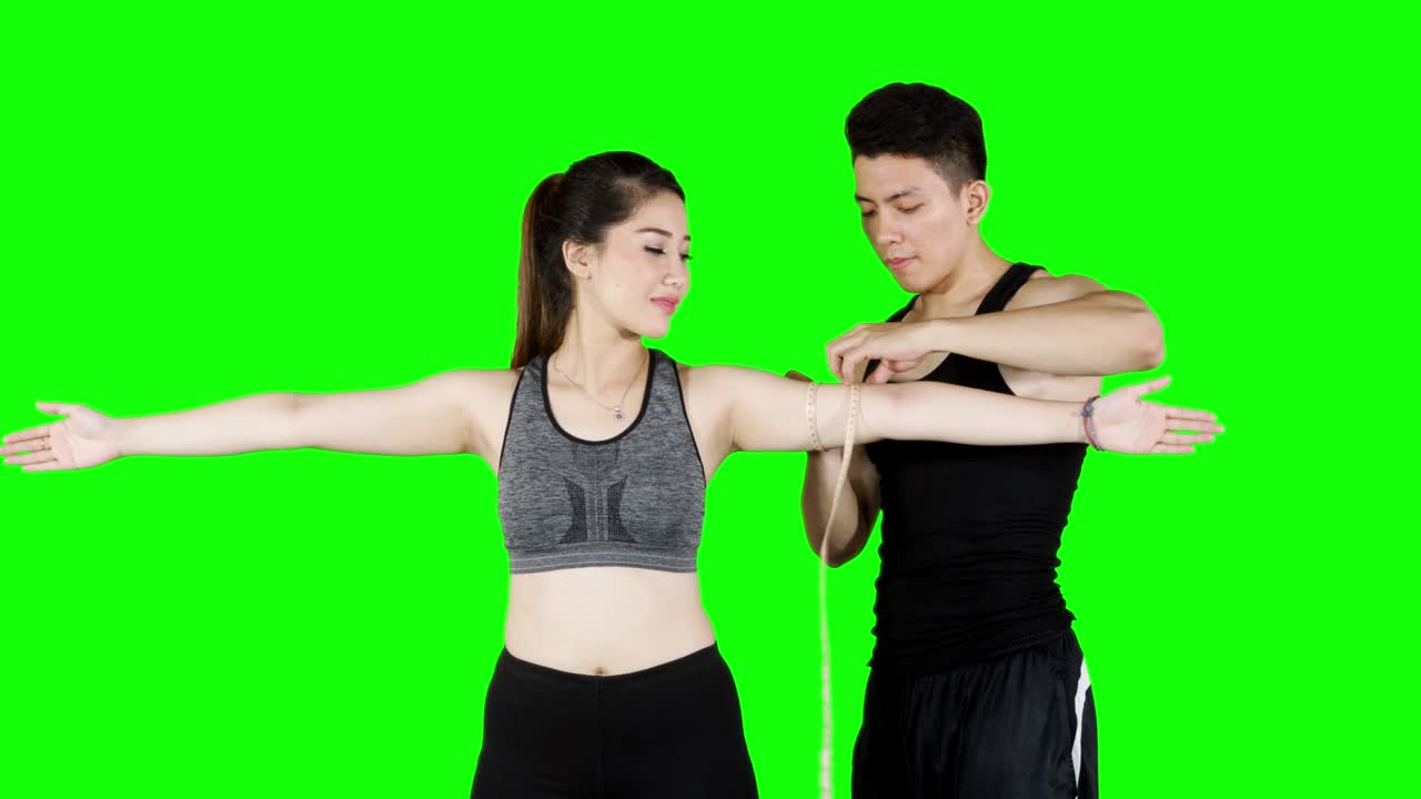 entrenador personal midiendo el músculo de los brazos del cliente