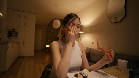 woman eating sushi at night