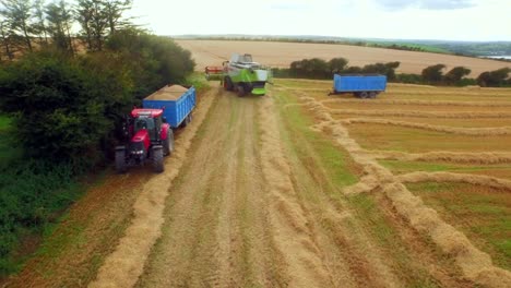 Drone-footage-of-golden-fields-and-agricultural-machinery