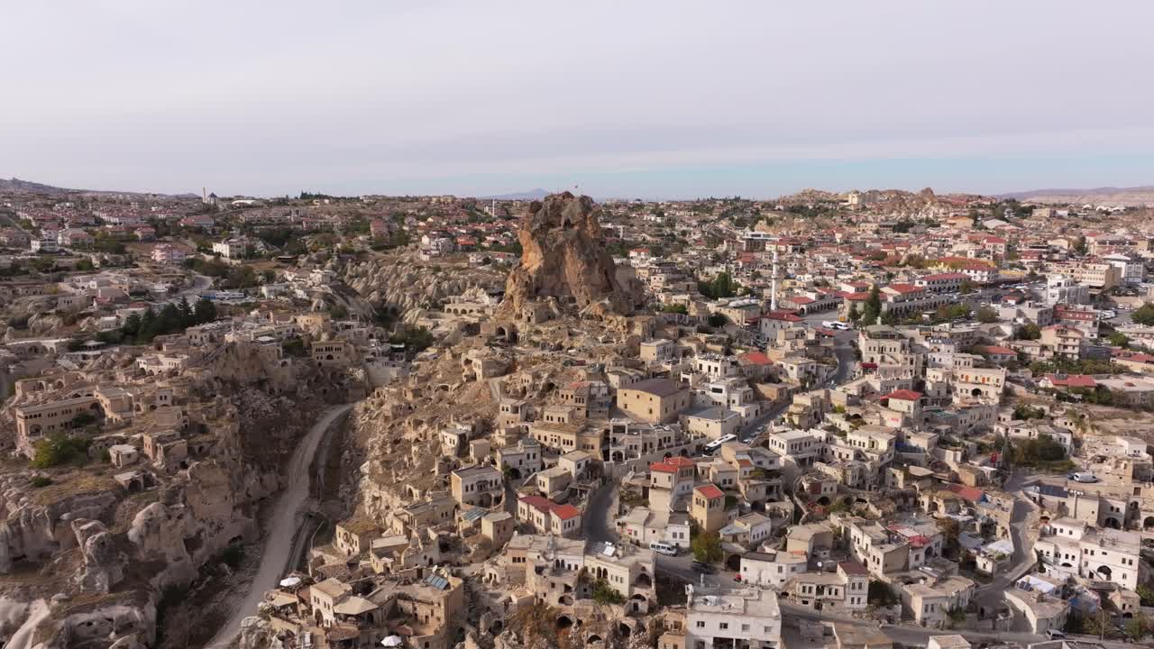 Vista aerea del Castello medievale di Ortahisar sopra un villaggio dai tetti di tegole