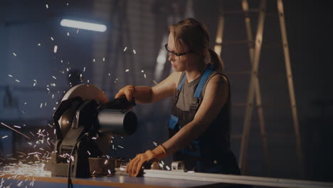 female metalworker operating a metal cutting saw