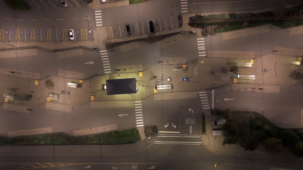 Parada de autobús vacía de noche: vista aérea vertical cenital con movimiento de cámara lento hacia dentro