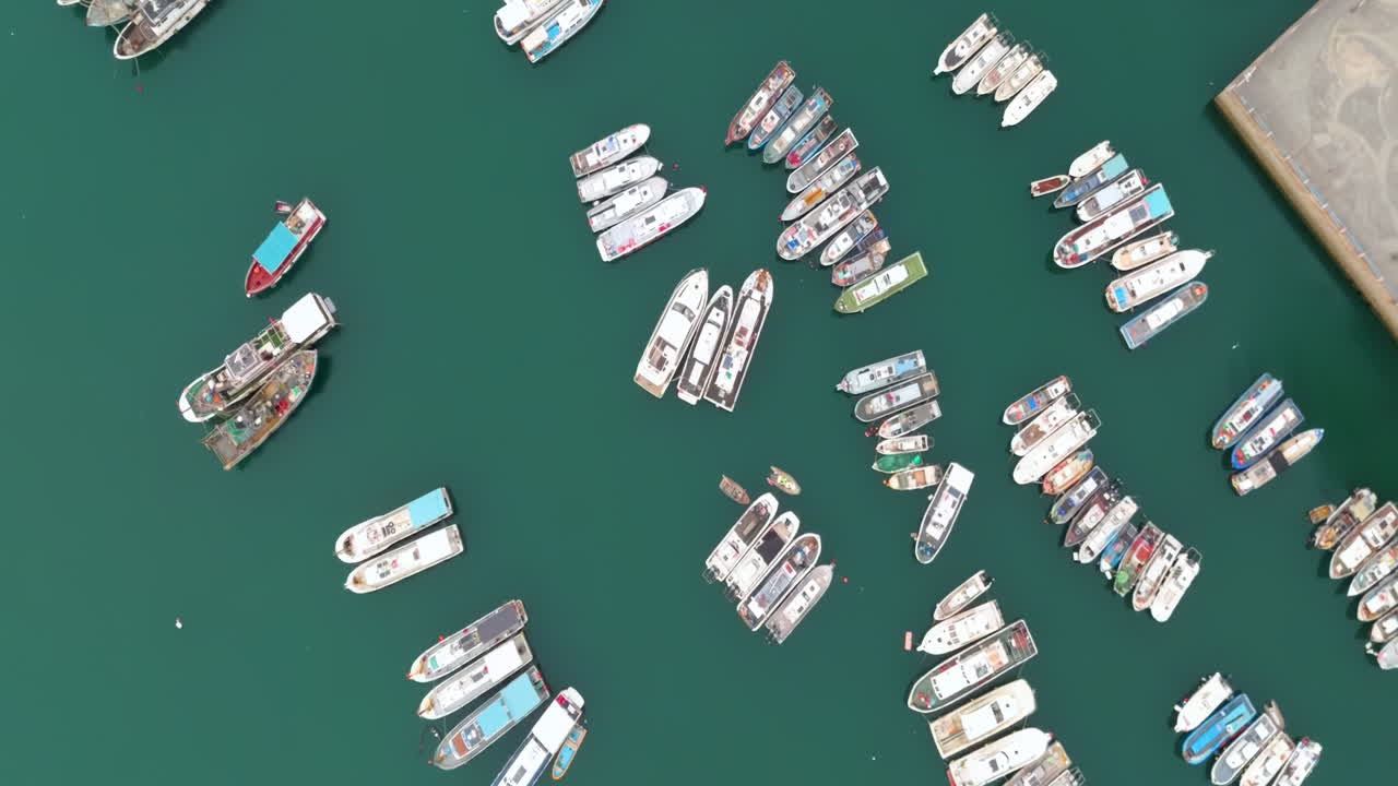 Aerial top down view of docked sailboats. High aerial view travel cruise luxury yachts and boats in marina parking in sea pier neatly arranged rows at harbor port