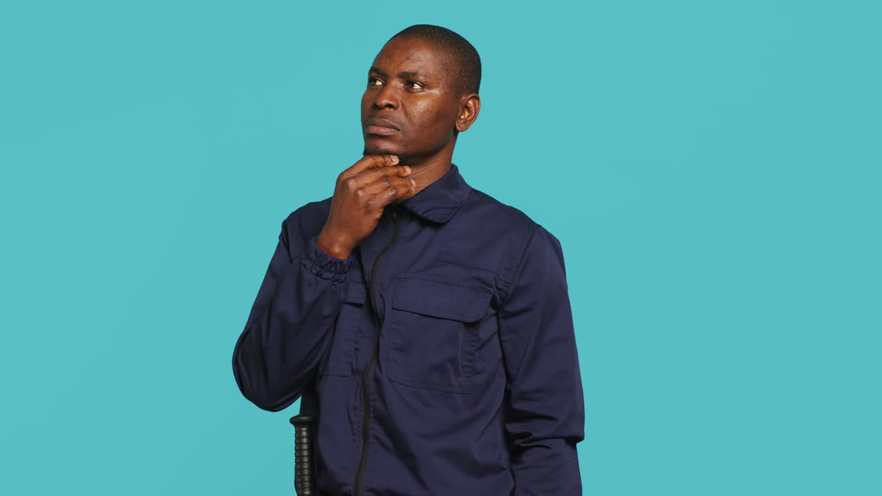 Portrait of pensive man in uniform rubbing chin