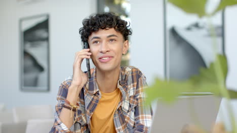 talking on smartphone, young teenage boy smiling and enjoying conversation at home