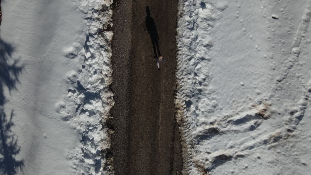 Walking Man in Snowy Asphalt