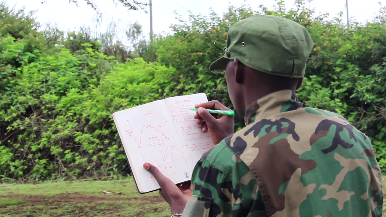 guerrilla militante africana repasando el plan de ataque en un folleto