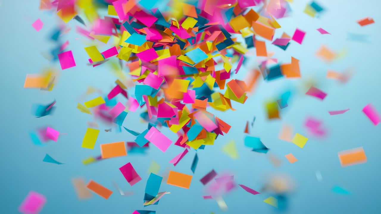 Confeti de colores que cae y se dispersa en el estudio tras su lanzamiento, mostrando el desenfoque de movimiento