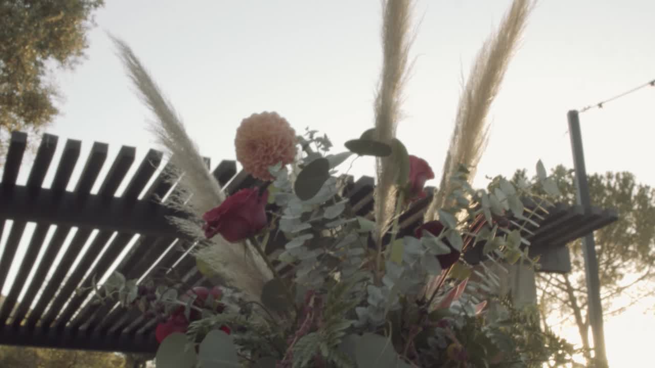 녹색 잎으로 만든 꽃다발과 신선한 꽃이 저녁 식탁에 서 있다