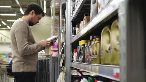 man shopping for automotive oil in a supermarket