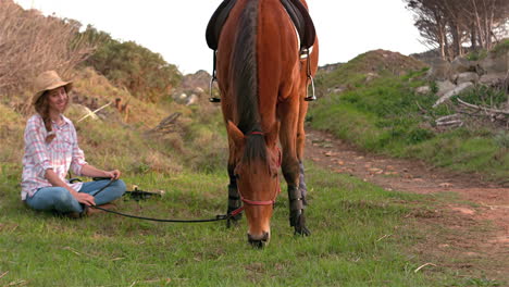 pretty woman sitting next to horse