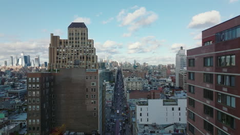 Forwards-fly-above-town-development.-Revealing-skyline-with-skyscrapers.-Long-straight-Broadway-street.-Manhattan,-New-York-City,-USA