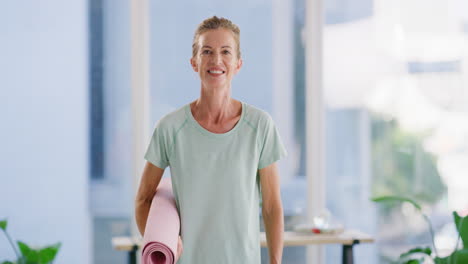 active mature woman holding a yoga mat