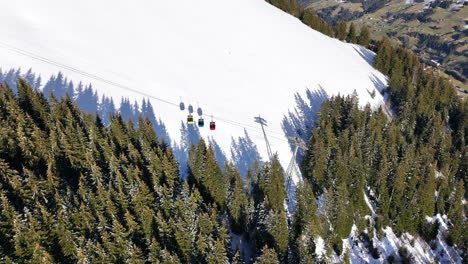 fotografía aérea del teleférico tschentenegg que se mueve cuesta abajo seguido de sombras en la nieve