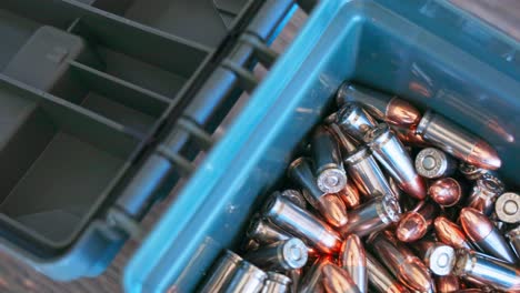 case of 9mm ammunition with the camera panning from left to right to show all of the cartridges in the plastic box