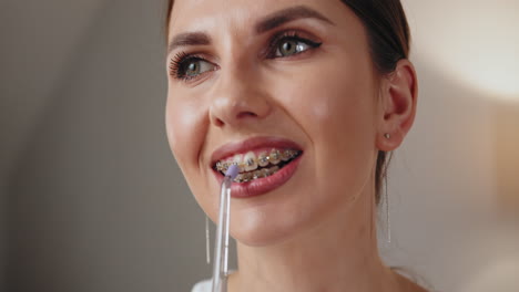 woman cleaning teeth with braces