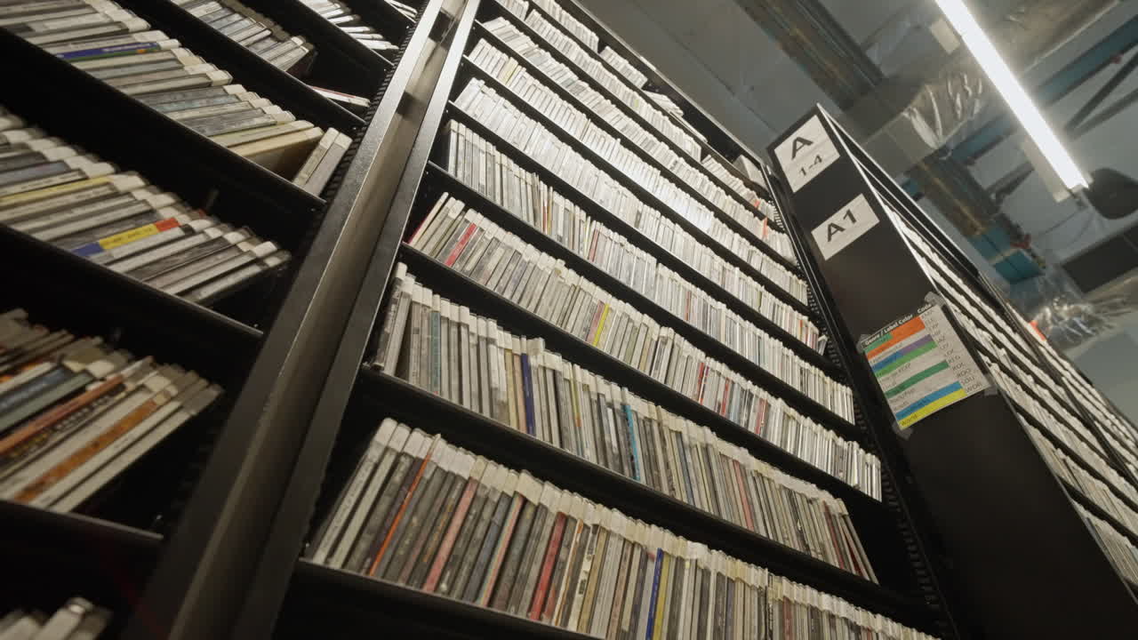 Records archive at KEXP in Seattle, Washington, USA. Vinyl collection stored on shelves with curated catalogs, showcasing music preservation, radio history and media culture in a studio