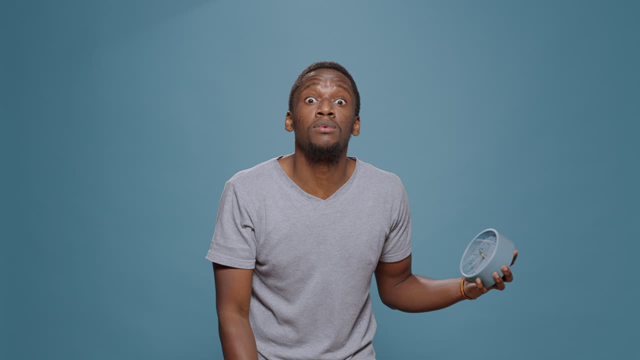 Shocked punctual man checking time on clock and running late