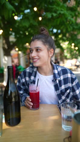 young woman enjoying a drink in an outdoor cafe